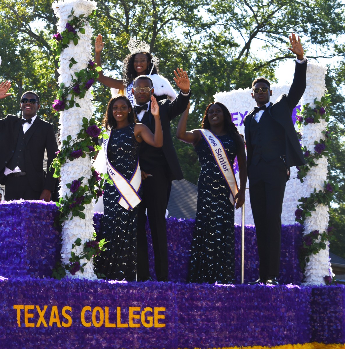 Male student in tuxedo escorts female student in evening gown.