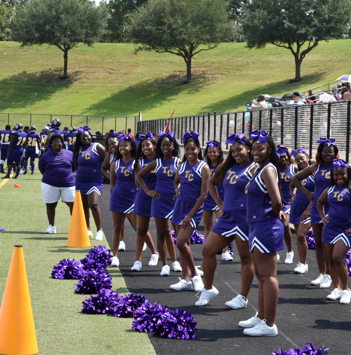 Texas College Cheerleaders in purple uniforms at a football game.